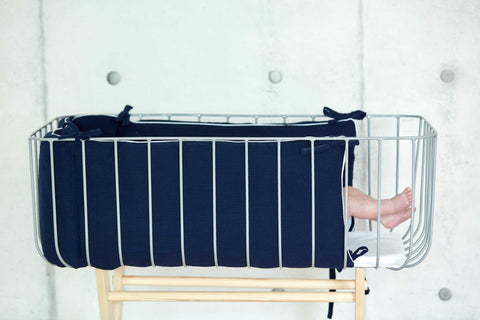 Bettumrandung aus Musselin in Dunkelblau im Babybett.