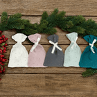 Fünf handgemachte KraftKids Musselin-Stoffsäckchen in Grün, Grau, Rosa und Weiß mit goldenen Punkten und weißen Bändern liegen arrangiert auf Holz mit Tannenzweigen - perfekt für deinen Adventskalender.
