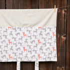 Der KraftKids Bezug für Wickeltischauflage kleine Rehkitze grau orange auf Weiß zeigt weiche Baumwolle, ein weißes Oberteil und grau-orange Cartoon-Hirsche auf einer Wäscheleine - perfekt als stilvoller Wickeltischauflage Bezug.