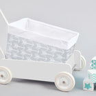 Ein KraftKids Körbchen "weiße Pfeile auf Grau" steht neben pastellfarbenen Stapelblöcken mit Zahlen und Mustern auf hellem, grauem Hintergrund.