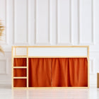 Ein minimalistisches Kinderhochbett im Stil des IKEA Kura, ausgestattet mit dem KraftKids Hochbettvorhänge Set 2+1 Doppelkrepp Rot Herbstrot, steht neben einer Korbvase mit Pampasgras und zwei Holzhockern vor einer strahlend weiß getäfelten Wand.